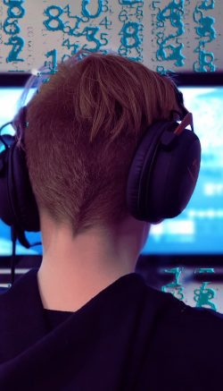 Foto de um adolescente jogando videogame com fone de ouvido